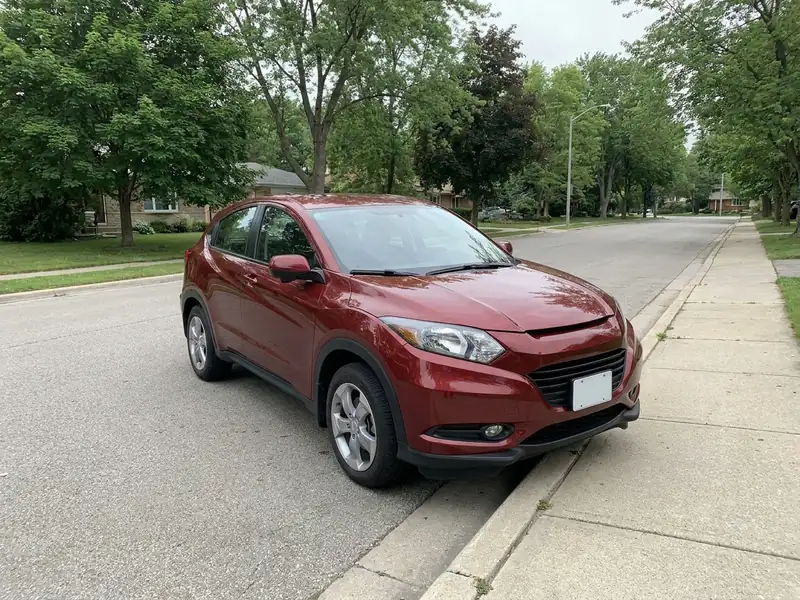 A good car photo: one red SUV, three-quarter view, the whole car and its wheels in frame, in daylight